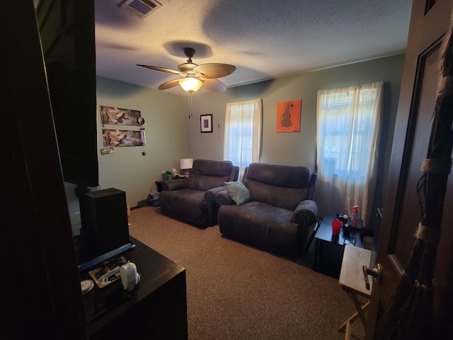 living room with carpet, ceiling fan, plenty of natural light, and a textured ceiling