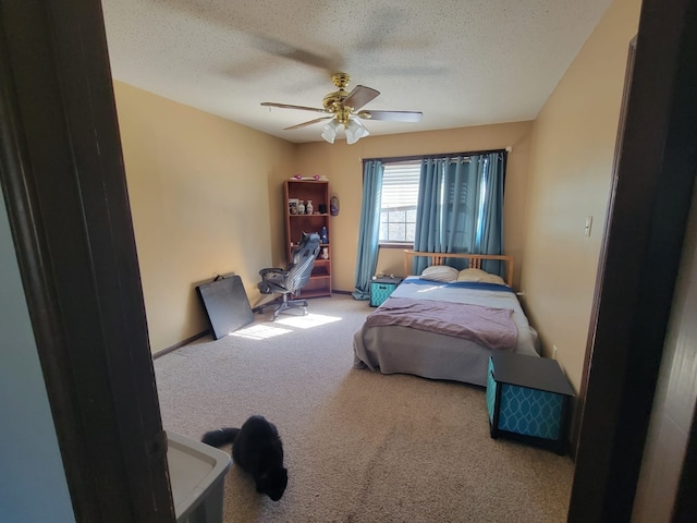 carpeted bedroom featuring ceiling fan and a textured ceiling