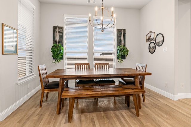 dining space with a notable chandelier and light hardwood / wood-style flooring