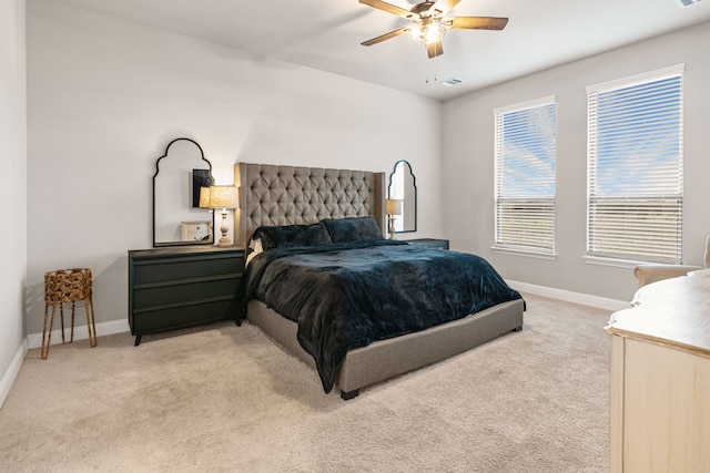 bedroom featuring light carpet, visible vents, baseboards, and a ceiling fan