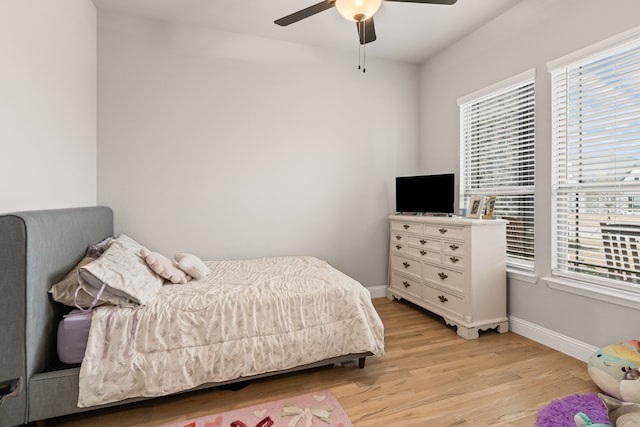 bedroom with light wood-type flooring, ceiling fan, and baseboards