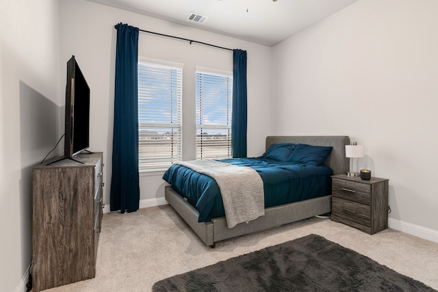 bedroom featuring baseboards, visible vents, and light colored carpet