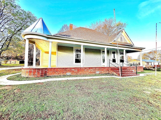 view of front of property featuring a front yard and covered porch