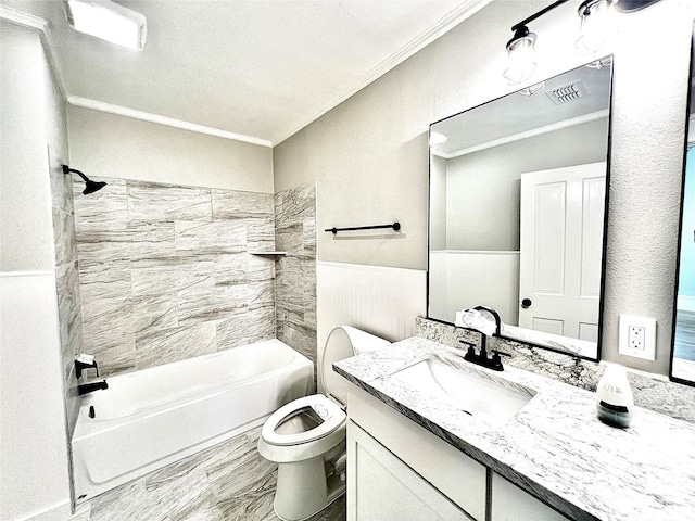 full bathroom featuring tiled shower / bath, ornamental molding, vanity, and toilet