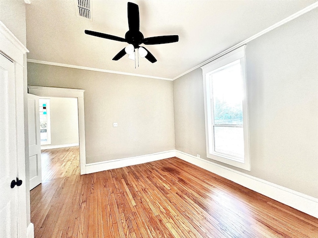 empty room with crown molding, hardwood / wood-style floors, and ceiling fan