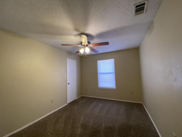 carpeted empty room with ceiling fan and a textured ceiling