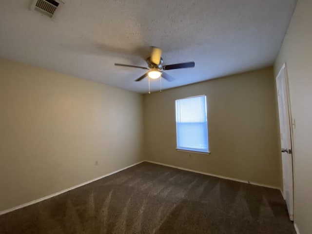 carpeted empty room featuring ceiling fan and a textured ceiling