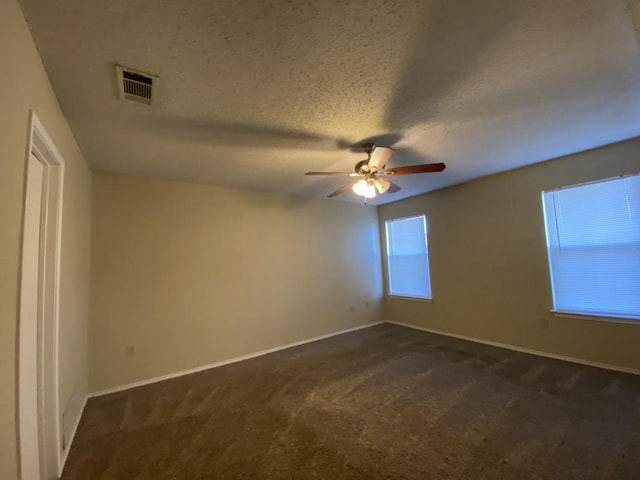 carpeted spare room with ceiling fan and a textured ceiling