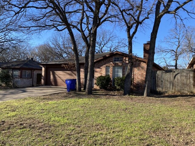 ranch-style house featuring a garage and a front yard