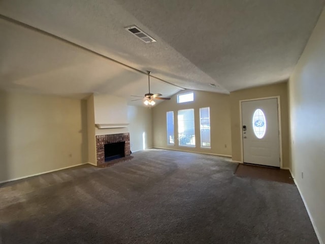 unfurnished living room featuring dark colored carpet, vaulted ceiling with beams, a textured ceiling, a brick fireplace, and ceiling fan