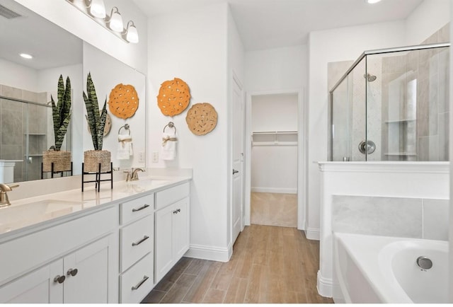 bathroom featuring vanity and independent shower and bath