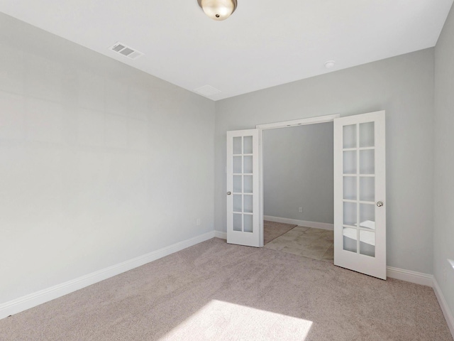 unfurnished room featuring light carpet and french doors