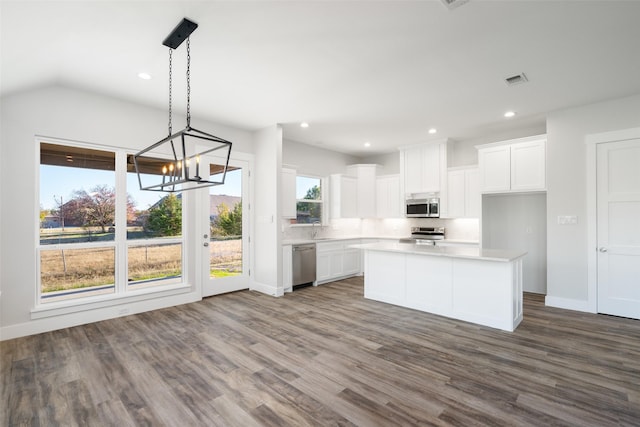 kitchen featuring white cabinetry, stainless steel appliances, a kitchen island, and pendant lighting