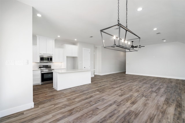 kitchen with a kitchen island, pendant lighting, white cabinetry, decorative backsplash, and stainless steel appliances