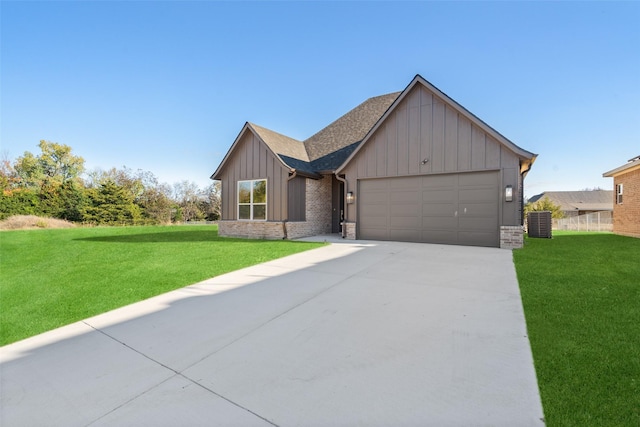 view of front of home featuring cooling unit, a garage, and a front yard