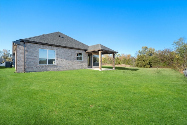 back of property with central AC unit, a lawn, and a patio area