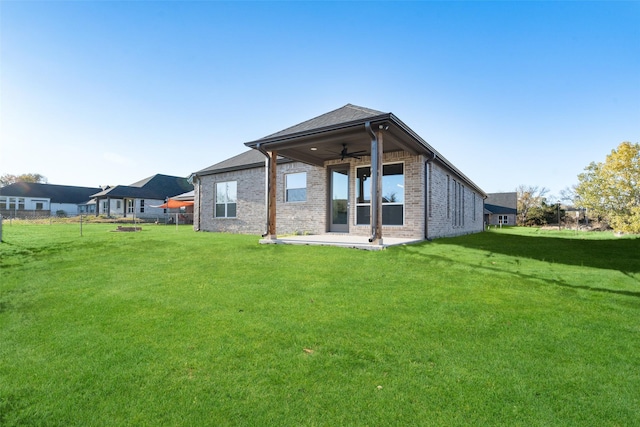 rear view of property with a lawn, ceiling fan, and a patio area