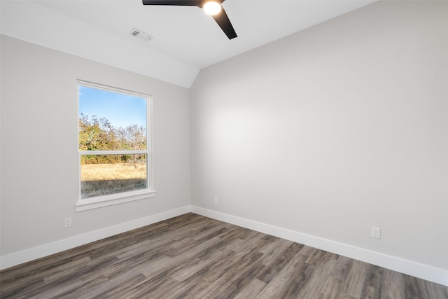 spare room featuring ceiling fan, dark hardwood / wood-style flooring, and vaulted ceiling