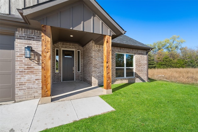 view of exterior entry with a lawn