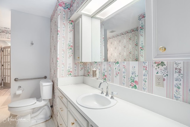 bathroom featuring tile patterned flooring, vanity, and toilet