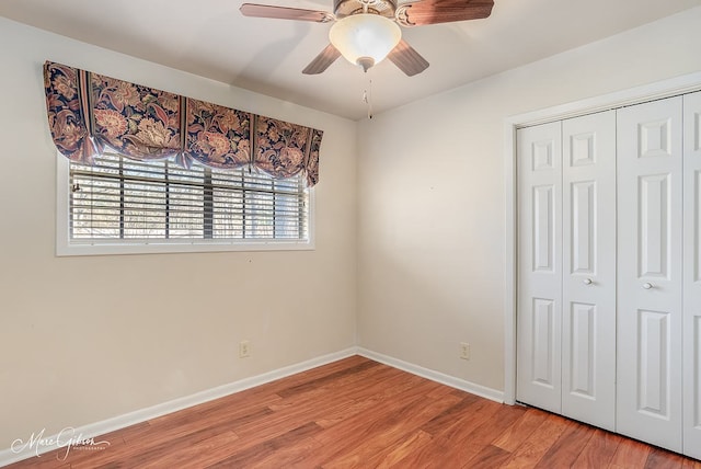 unfurnished bedroom with ceiling fan, wood-type flooring, and a closet