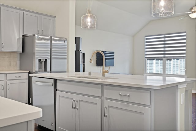 kitchen featuring gray cabinetry, ceiling fan, sink, backsplash, and appliances with stainless steel finishes