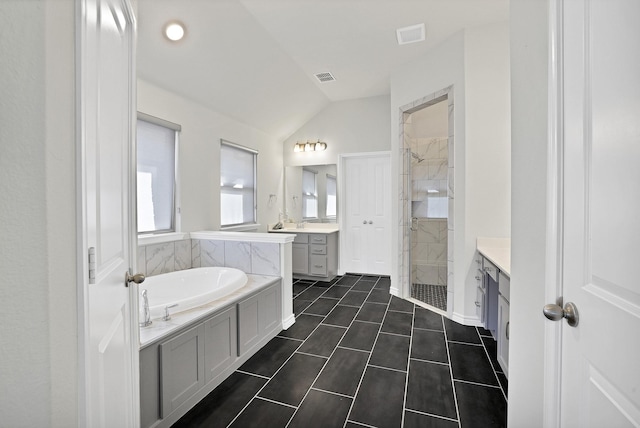 bathroom with tile patterned flooring, lofted ceiling, vanity, and independent shower and bath