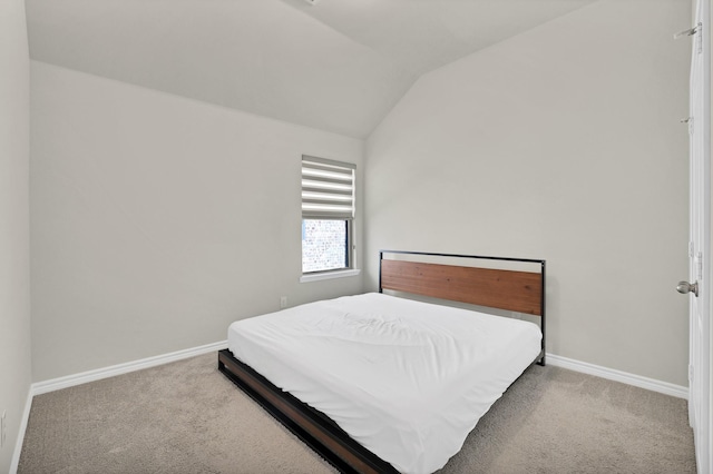 bedroom with carpet floors and lofted ceiling