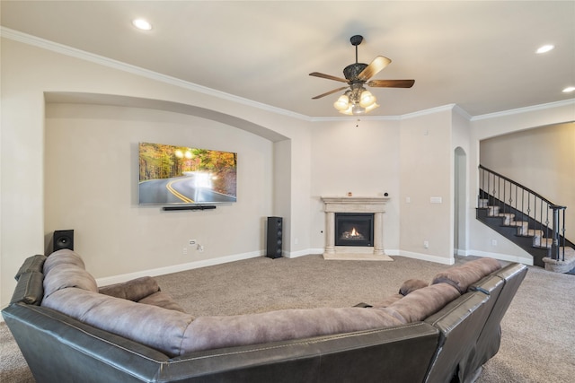 carpeted living room with ceiling fan and ornamental molding