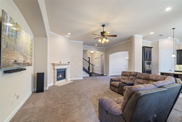 carpeted living room featuring ceiling fan and ornamental molding