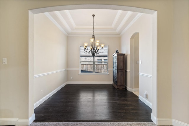 unfurnished dining area with ornamental molding, dark hardwood / wood-style floors, a raised ceiling, and a notable chandelier