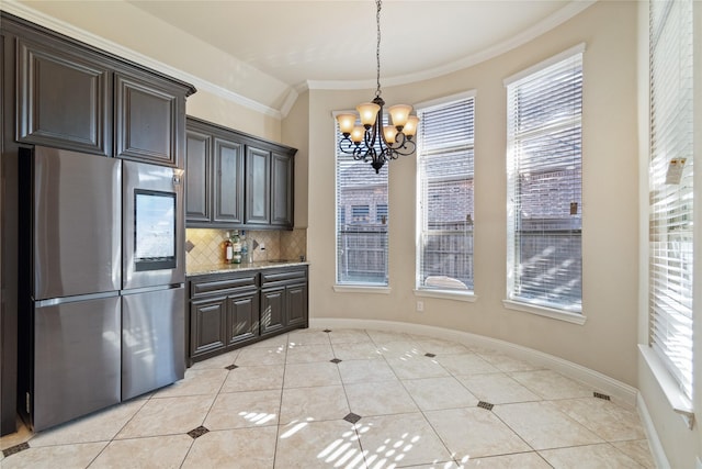 kitchen featuring a notable chandelier, backsplash, stainless steel fridge, pendant lighting, and light tile patterned floors