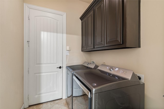 laundry room featuring cabinets, light tile patterned floors, and separate washer and dryer