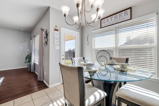 tiled dining area with a chandelier and vaulted ceiling