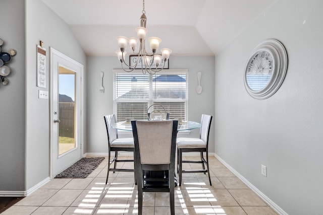 tiled dining area featuring lofted ceiling and a notable chandelier