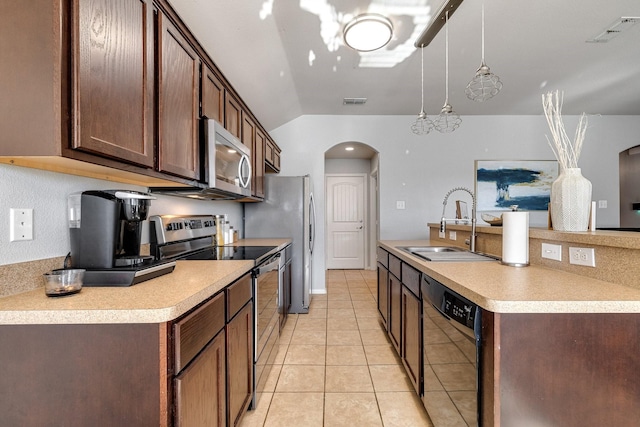 kitchen with sink, pendant lighting, vaulted ceiling, a center island with sink, and appliances with stainless steel finishes