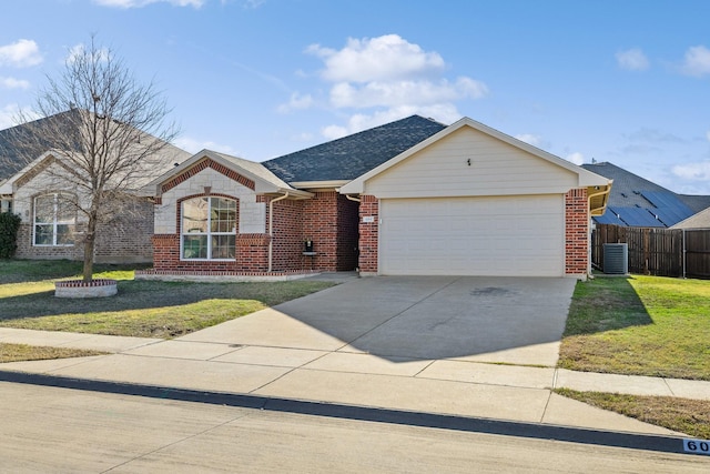 ranch-style home featuring cooling unit, a garage, and a front yard