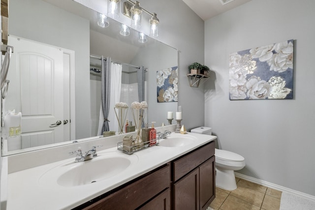 bathroom featuring tile patterned flooring, vanity, toilet, and walk in shower