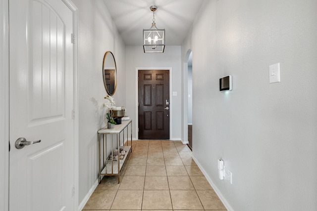 doorway to outside featuring light tile patterned flooring and a chandelier