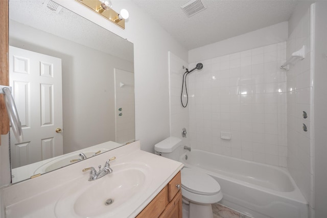 full bathroom featuring vanity, toilet, a textured ceiling, and tiled shower / bath combo