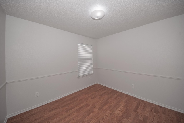 unfurnished room featuring wood-type flooring and a textured ceiling