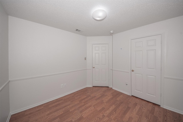 unfurnished bedroom with a textured ceiling and hardwood / wood-style flooring