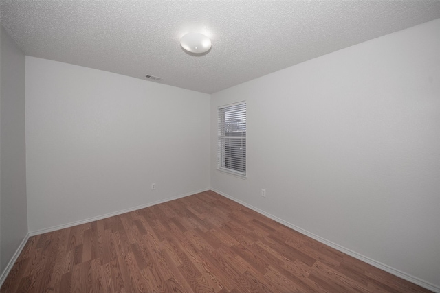 unfurnished room featuring hardwood / wood-style floors and a textured ceiling