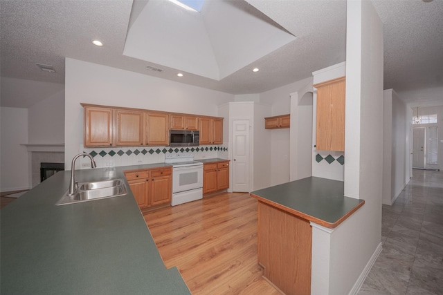 kitchen featuring kitchen peninsula, white range with electric cooktop, sink, and tasteful backsplash