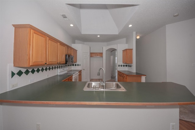 kitchen with kitchen peninsula, electric range, sink, and decorative backsplash