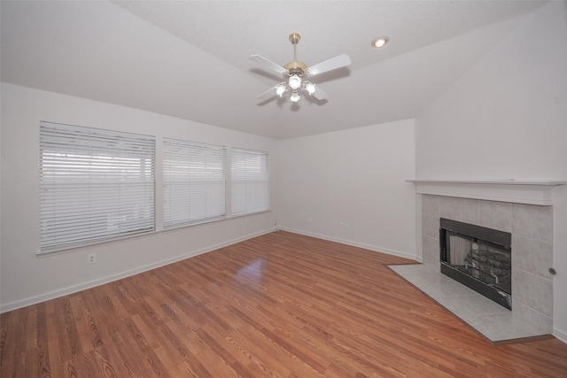 unfurnished living room with ceiling fan, wood-type flooring, a fireplace, and vaulted ceiling