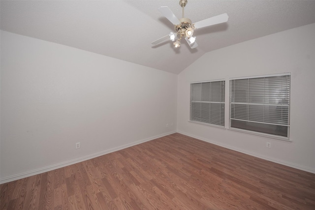 spare room with ceiling fan, wood-type flooring, and vaulted ceiling