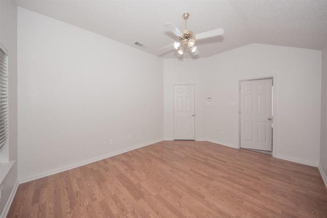 unfurnished room featuring a textured ceiling, ceiling fan, lofted ceiling, and light wood-type flooring