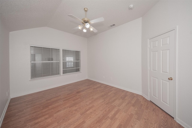 unfurnished room with a textured ceiling, light hardwood / wood-style flooring, ceiling fan, and vaulted ceiling