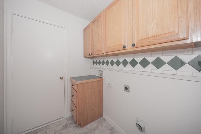 clothes washing area featuring hookup for an electric dryer, washer hookup, cabinets, a textured ceiling, and hookup for a gas dryer